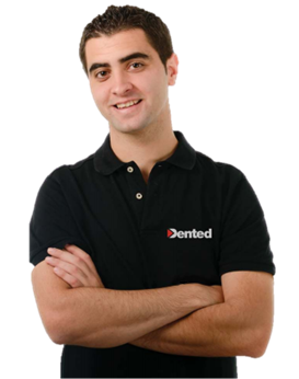 Smiling Dented technician wearing a black Dented polo shirt with arms crossed